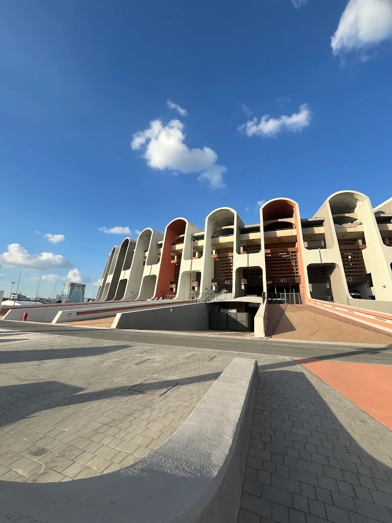 Zayed Sports City stadium exterior under blue sky, Abu Dhabi.