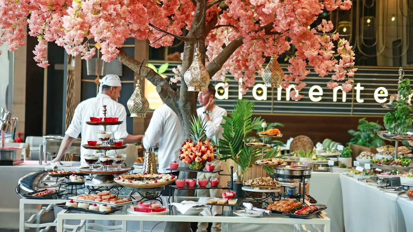 Buffet setup under cherry blossoms at The Kana Cafe Downtown Dubai.