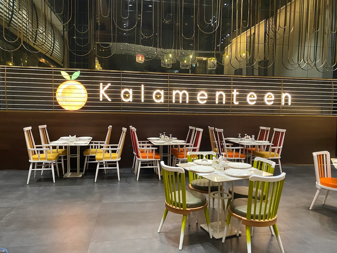 Kana Cafe Dubai, colorful chairs, modern decor, illuminated sign.