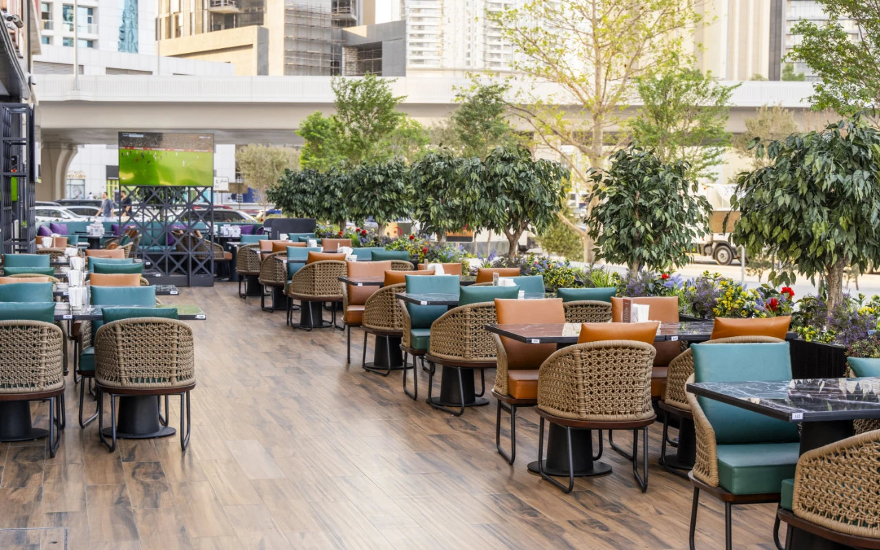 Outdoor seating at Cafe De Paris, Downtown Dubai, with greenery.