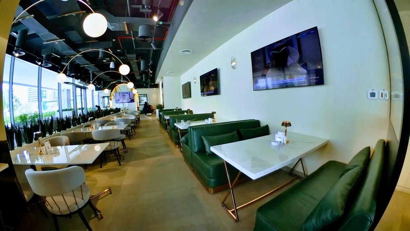 Modern interior of Cafe De Paris, Downtown Dubai, with green seating.