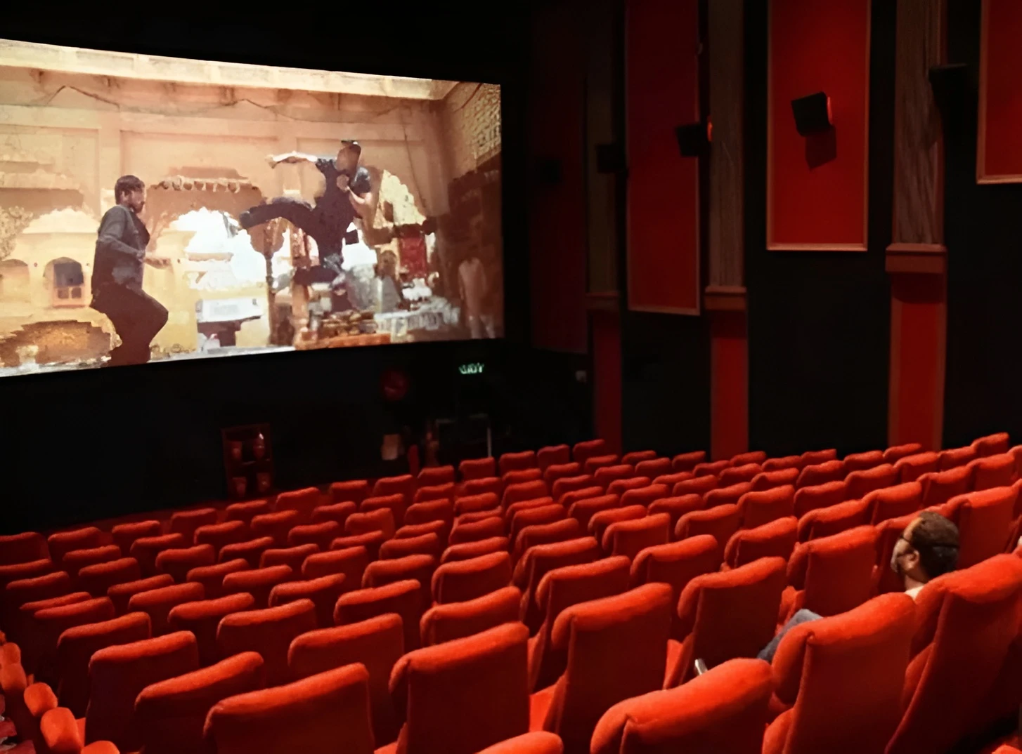Gulf Cinema Ras Al Khaimah with red seats and movie screen.