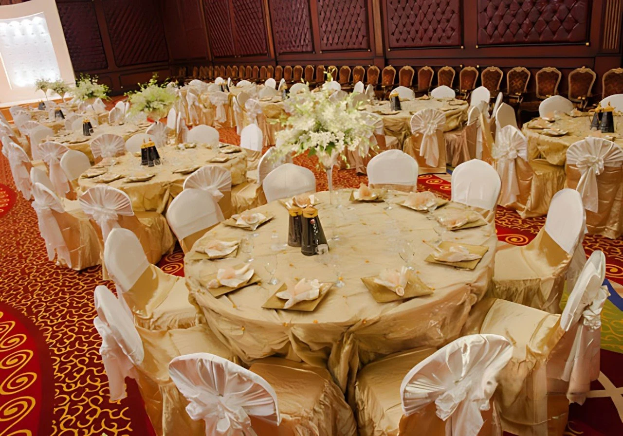 Elegant banquet setup at Regency Hall Doha with gold tablecloths.