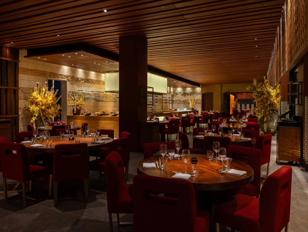 Elegant dining area at Zuma Restaurant Doha with red chairs.