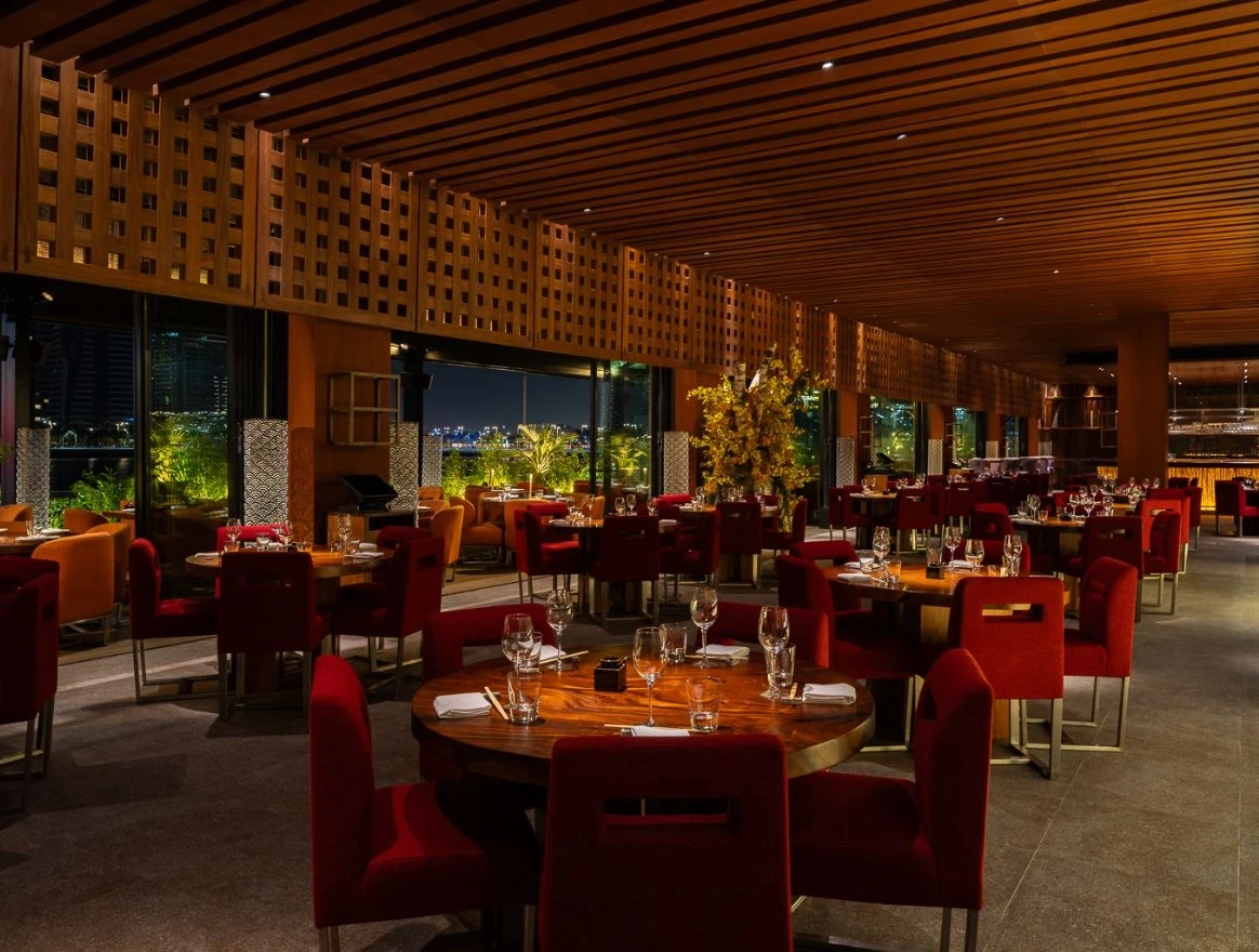 Zuma Restaurant Doha dining room with red seating and wooden accents.