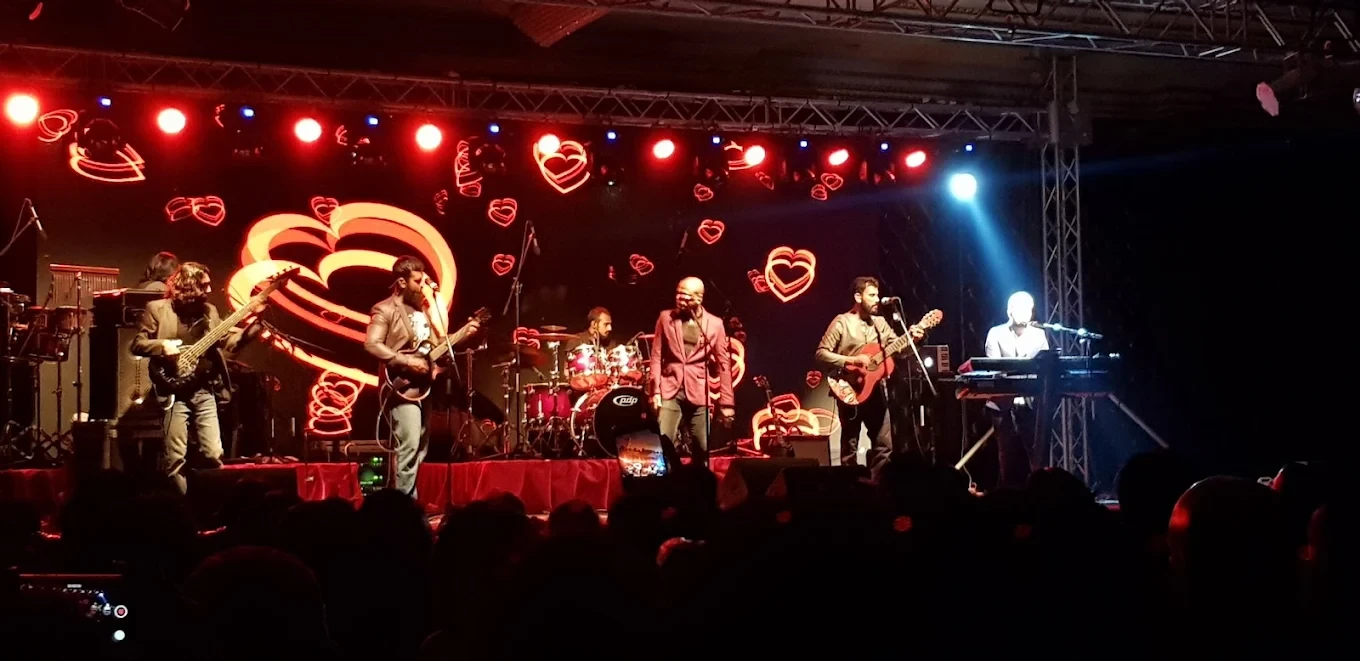 Band performing on stage at Regency Hall Doha with heart lights.