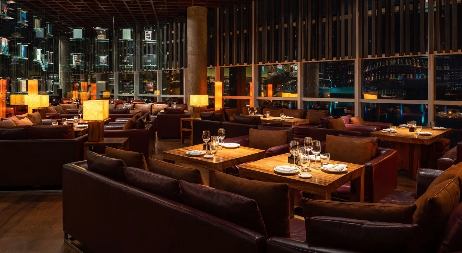 Elegant dining area at Zuma Restaurant Doha, featuring warm lighting.