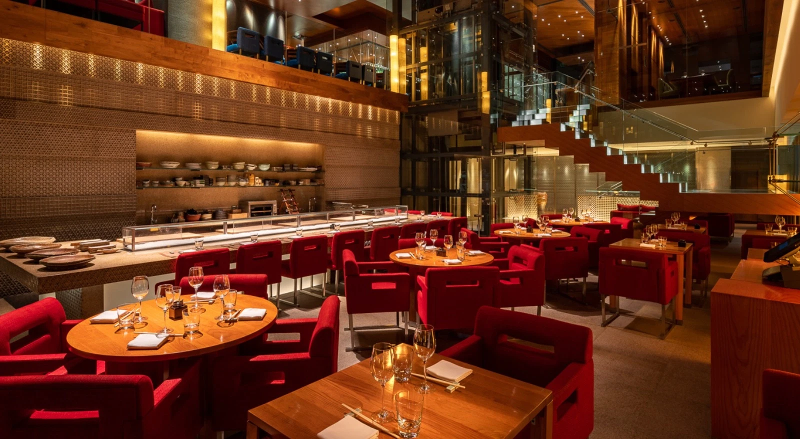 Zuma Doha dining area with red chairs and wooden tables.
