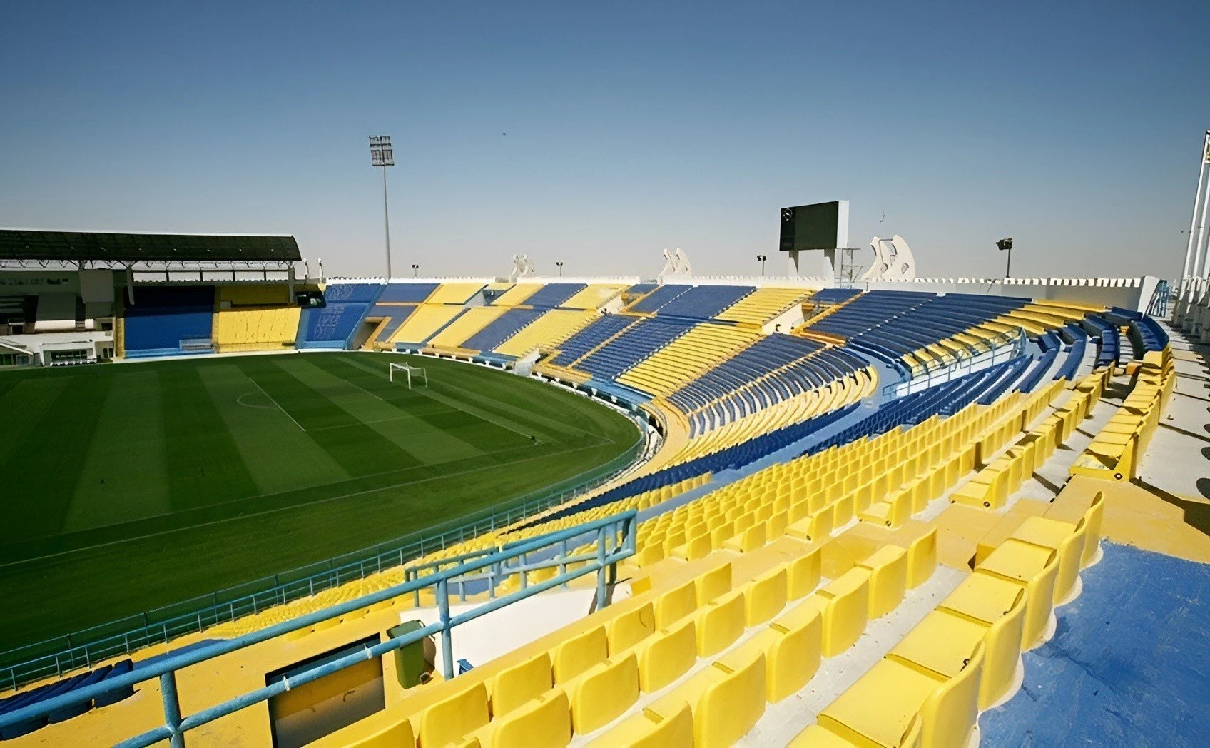 Thani Bin Jassim Stadium seating, Al Rayyan, empty and colorful.