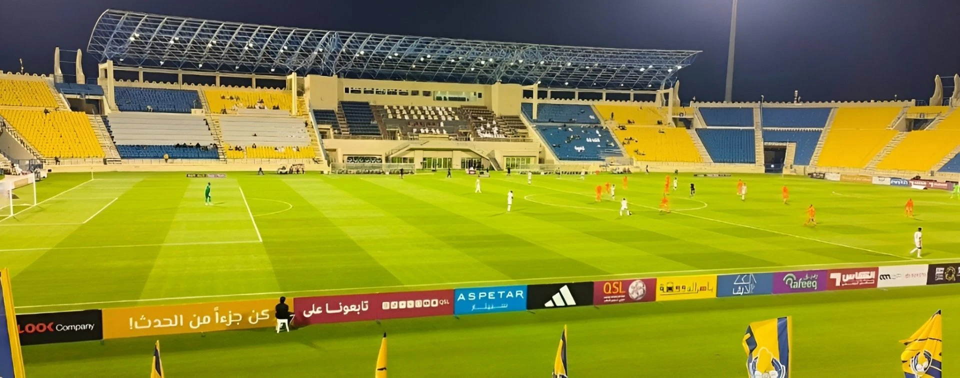 Thani Bin Jassim Stadium, Al Rayyan, night soccer match in progress.