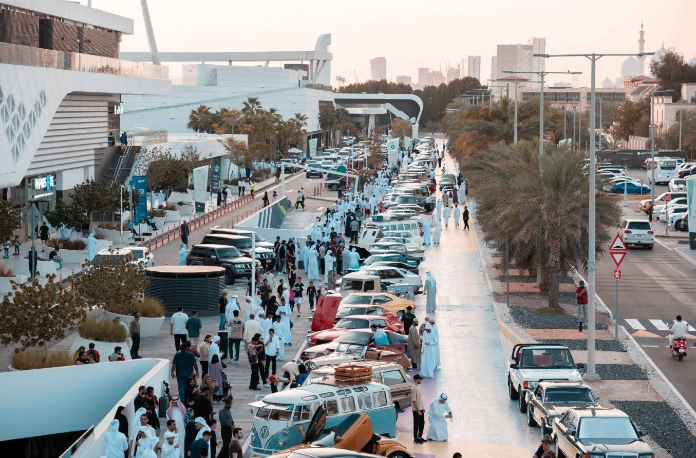 Crowded Al Qana promenade with vintage cars, Abu Dhabi.