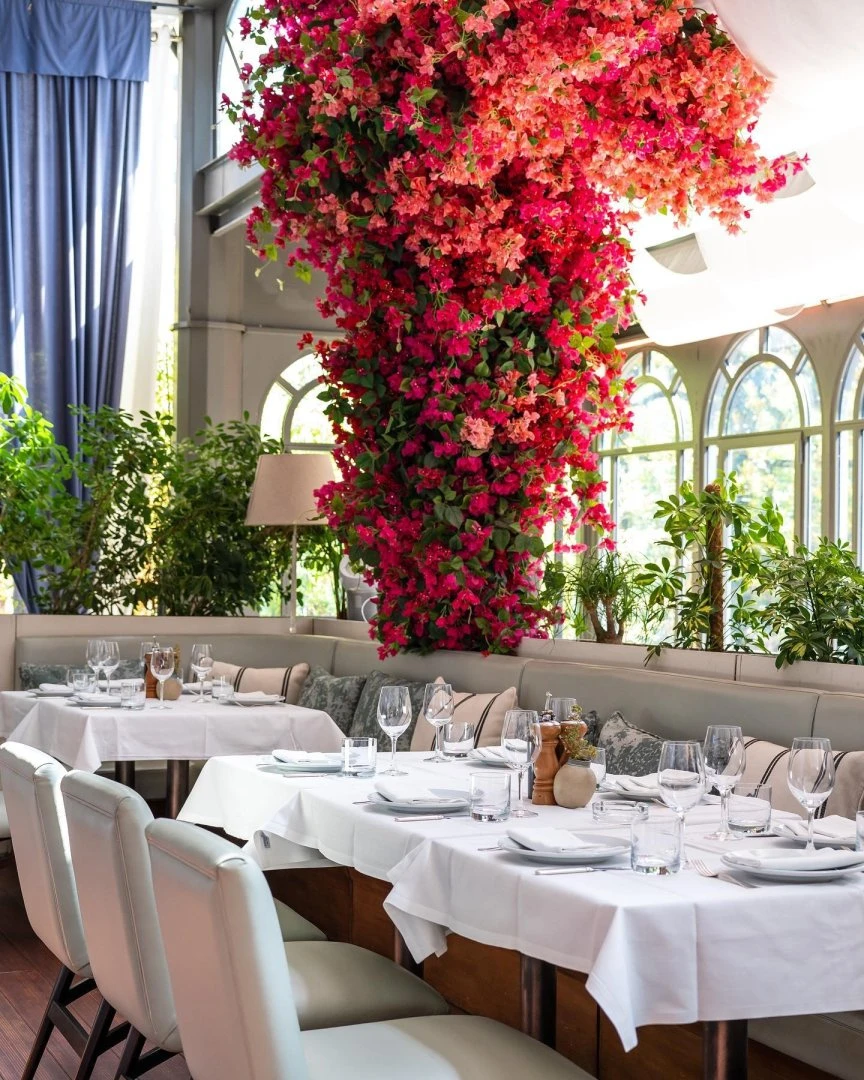 Elegant dining area with vibrant flowers at Gaia Restaurant Doha.
