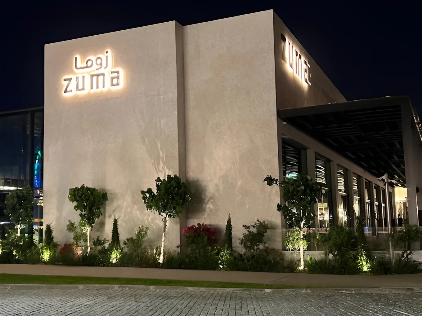 Zuma Restaurant Doha exterior at night with illuminated signage.