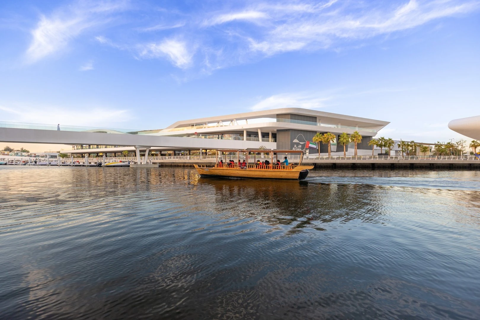 Boat on water near Al Qana, Abu Dhabi, modern building in background.
