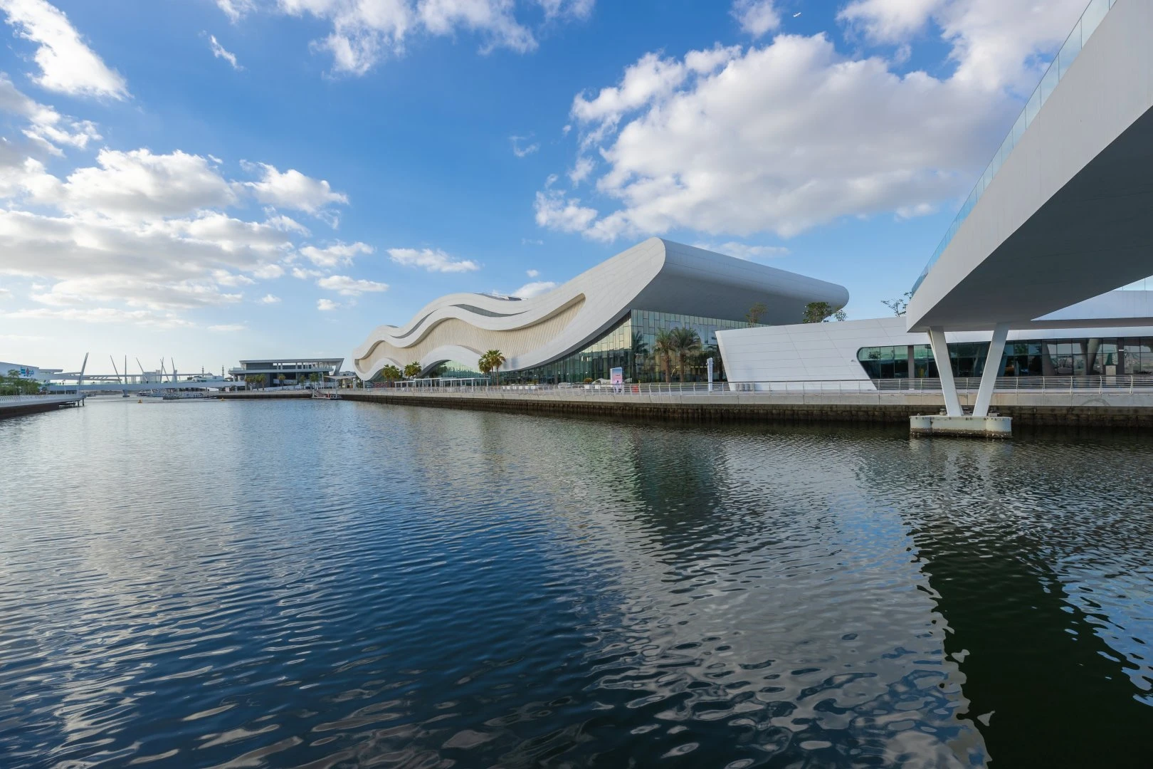 Modern architecture at Al Qana, Abu Dhabi waterfront under blue sky.