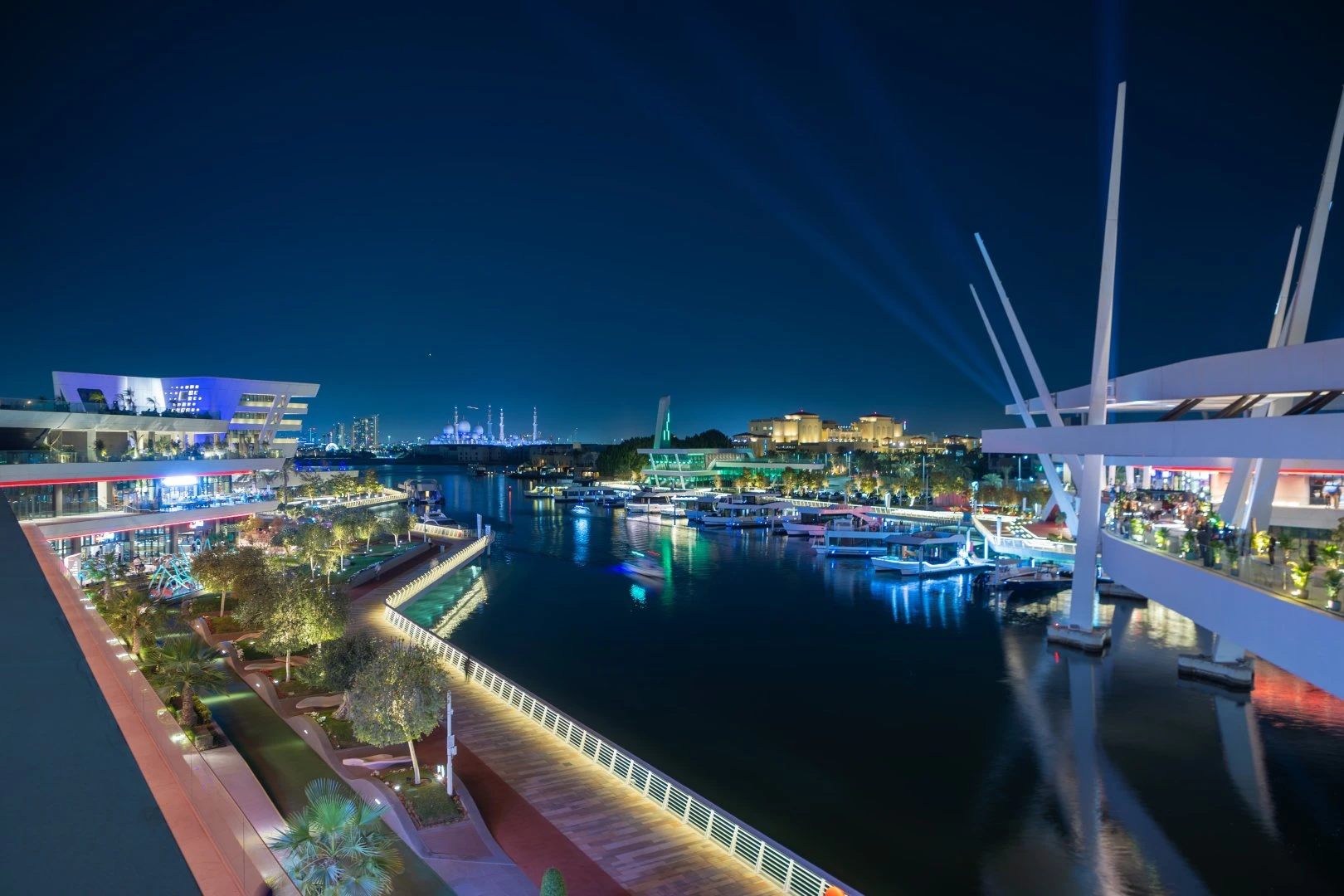 Night view of Al Qana waterfront, Abu Dhabi, with illuminated buildings.