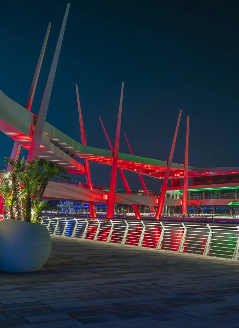 Al Qana illuminated walkway with red lights, Abu Dhabi night scene.