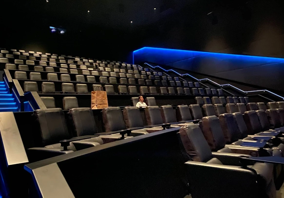 Empty AMC Cinemas Ajdan Walk theater with one person seated, Al Khobar.