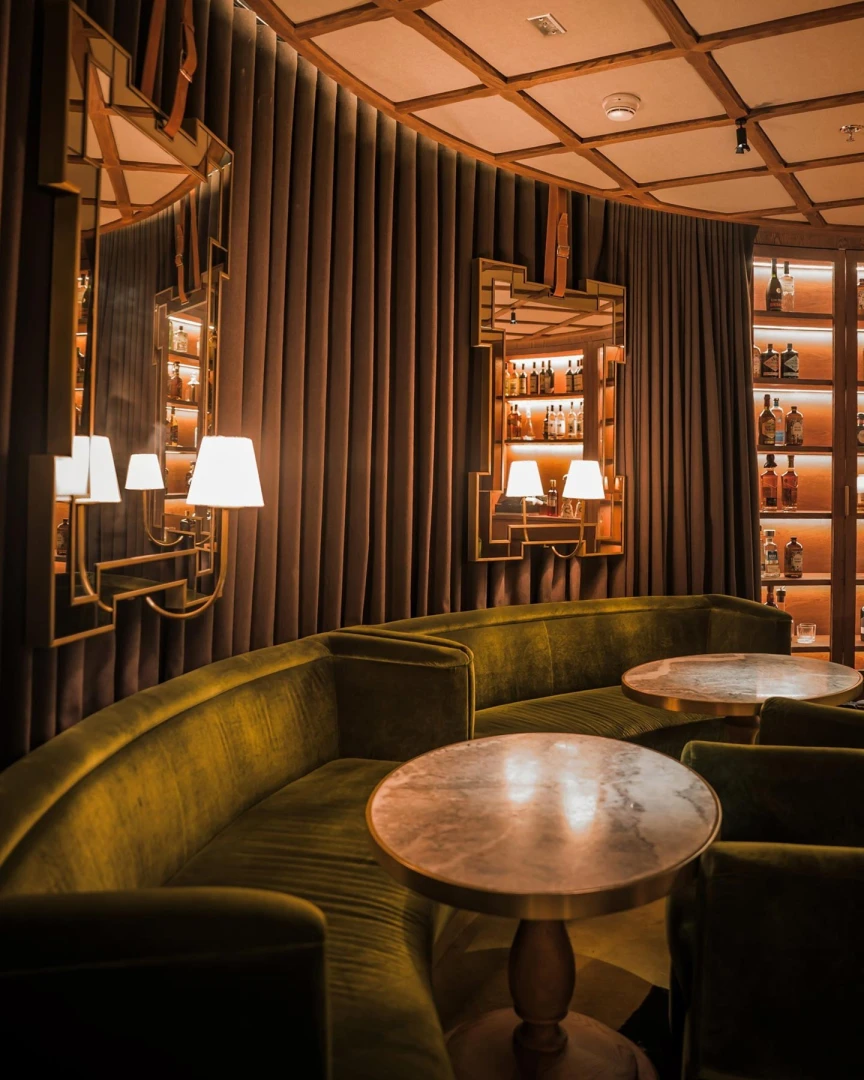 Elegant lounge with velvet seating at The Guild Dubai.