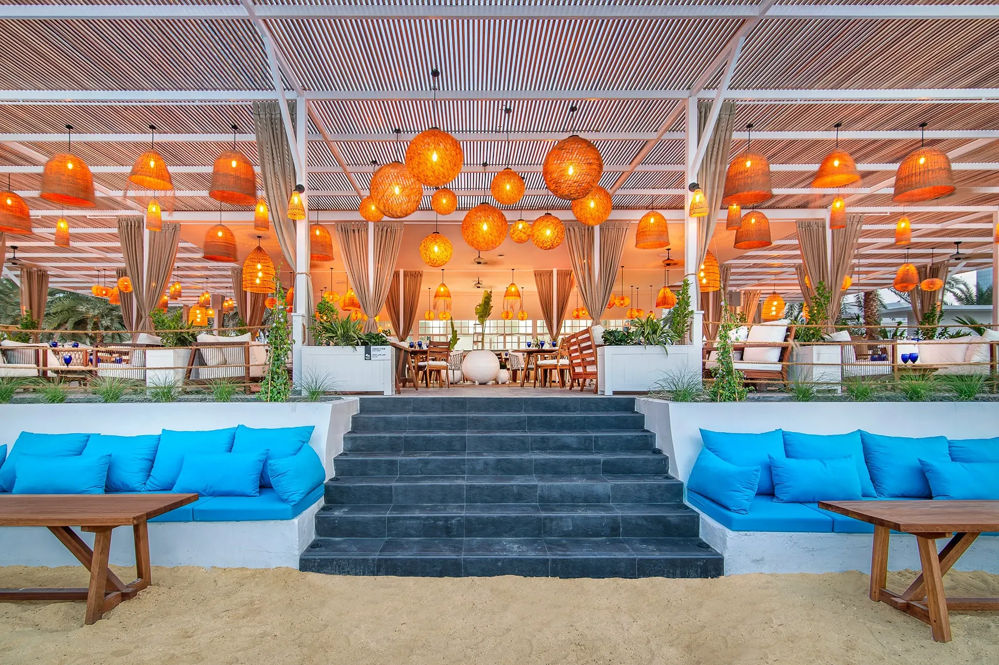 West Bay Lounge Abu Dhabi with vibrant lighting and beach seating.