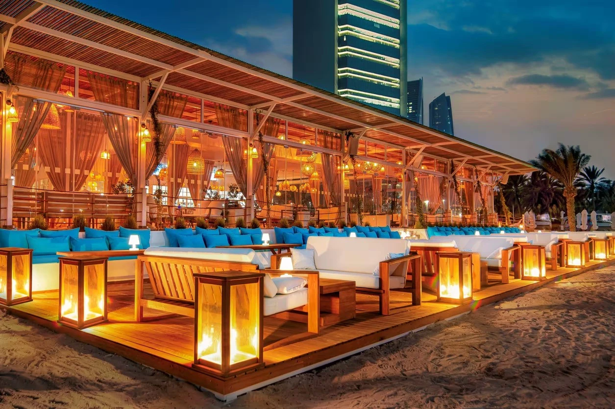 West Bay Lounge Abu Dhabi beachfront seating with lanterns at dusk.