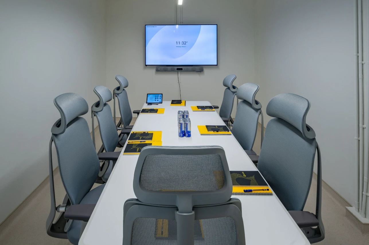 Expo City Dubai meeting room with grey chairs and screen.