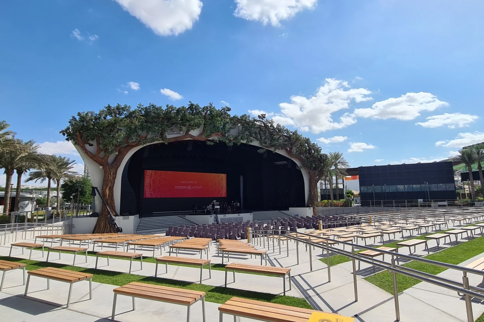 Outdoor stage at Al Forsan Park, Expo City Dubai, under blue sky.