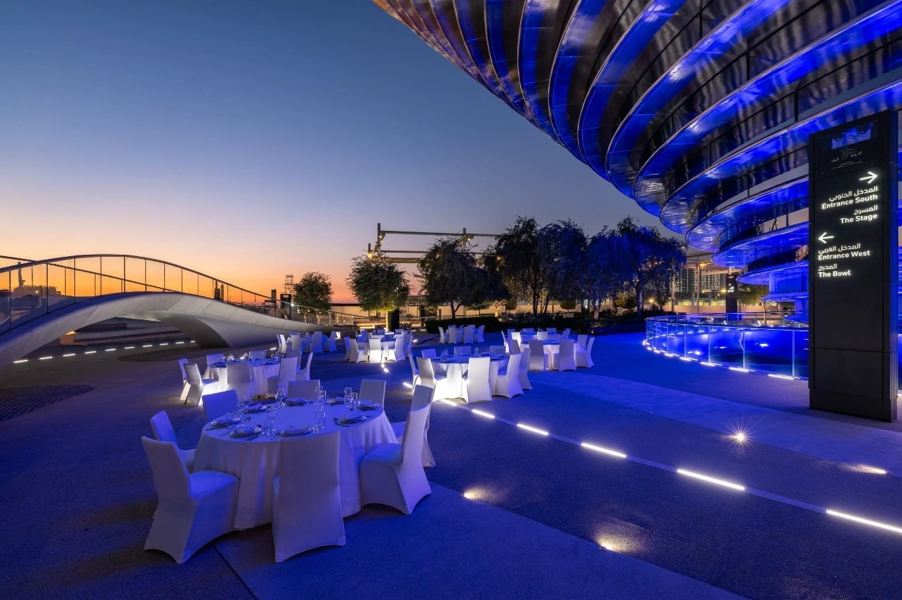 Elegant outdoor dining setup at Expo City Dubai during sunset.