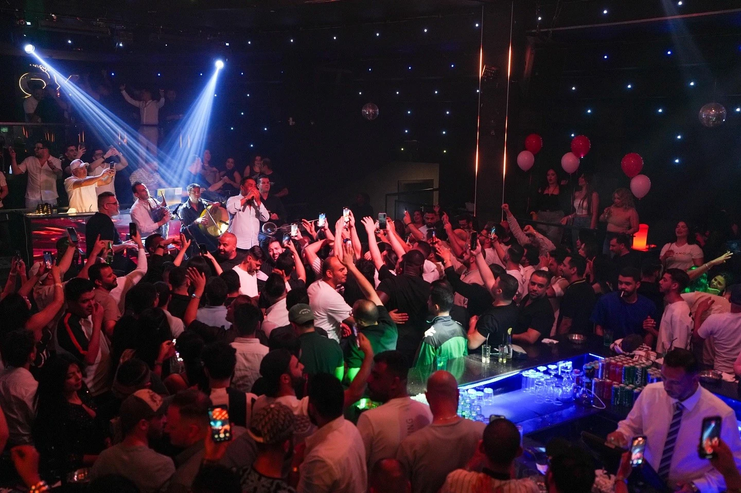 Crowd enjoying live music at OX Club Doha, vibrant atmosphere.