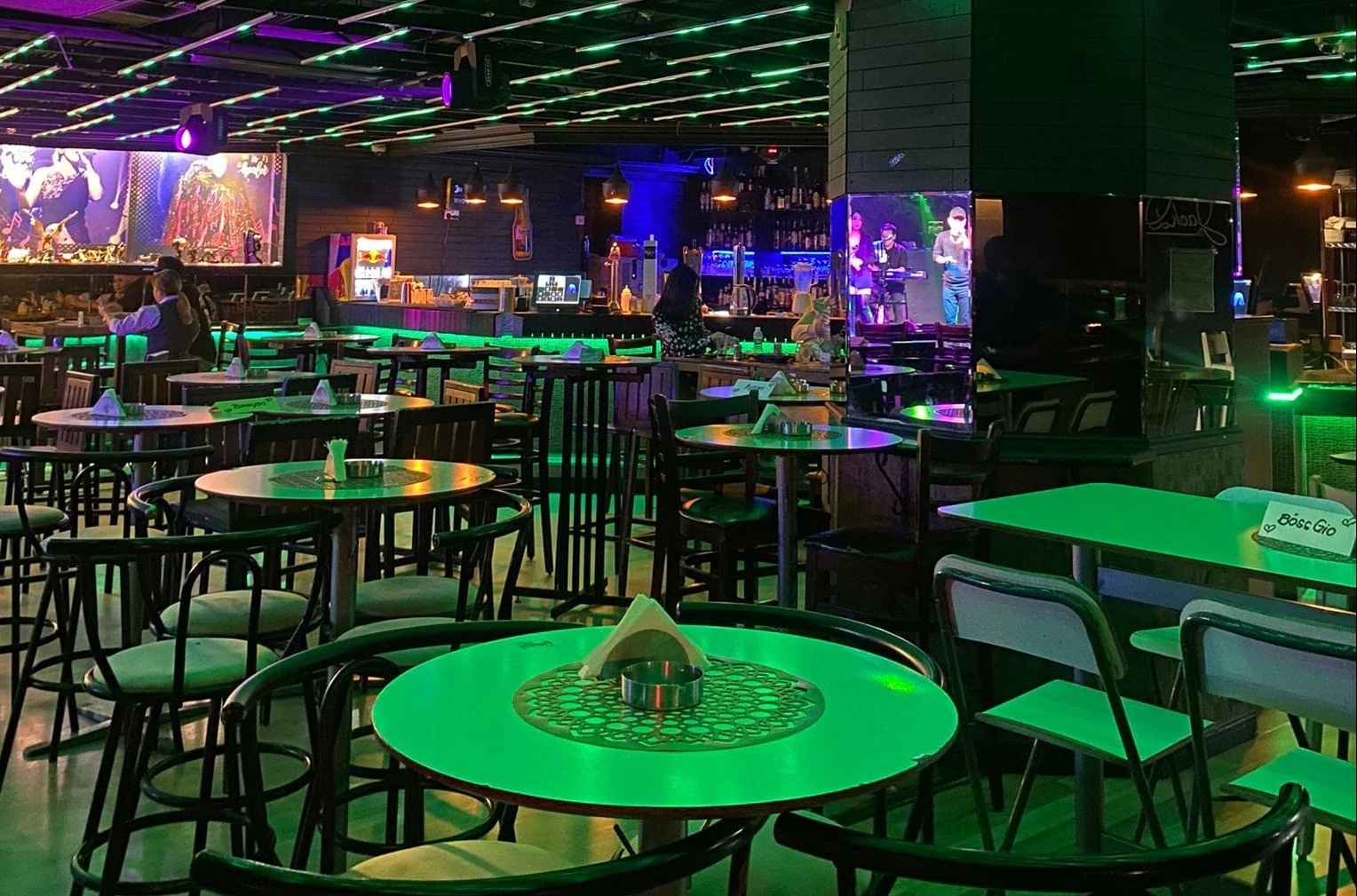 Maharlika Night Club Doha interior with green-lit tables and stage.