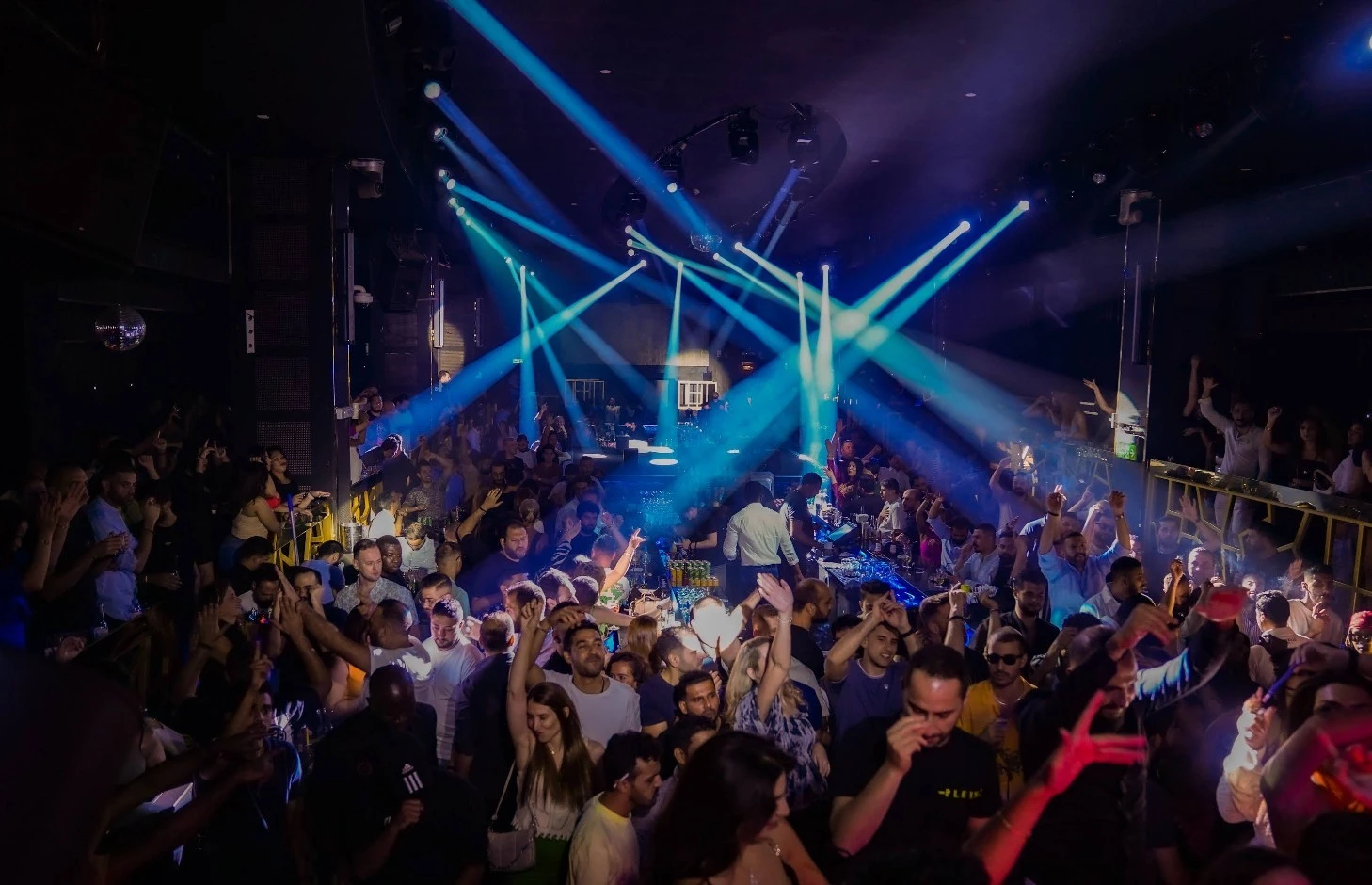 Crowded dance floor with vibrant lights at OX Club Doha.
