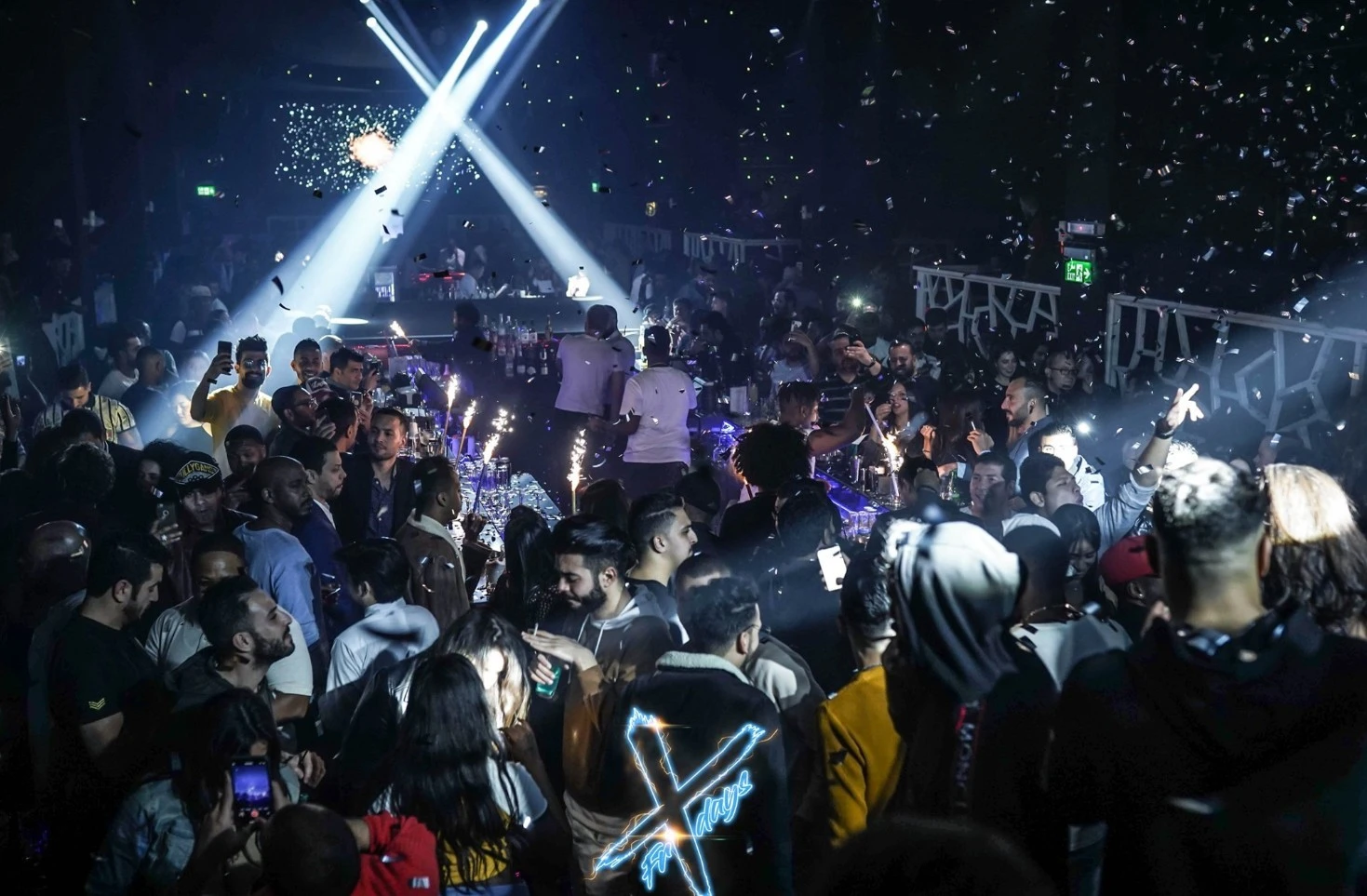 Crowded nightclub scene at OX Club Doha with lights and confetti.