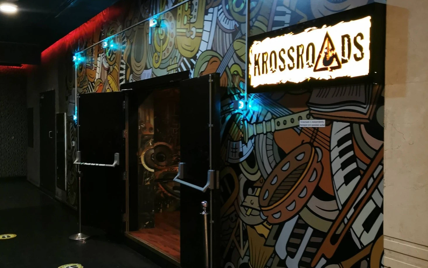 Entrance to Krossroads Club Doha with colorful mural and sign.