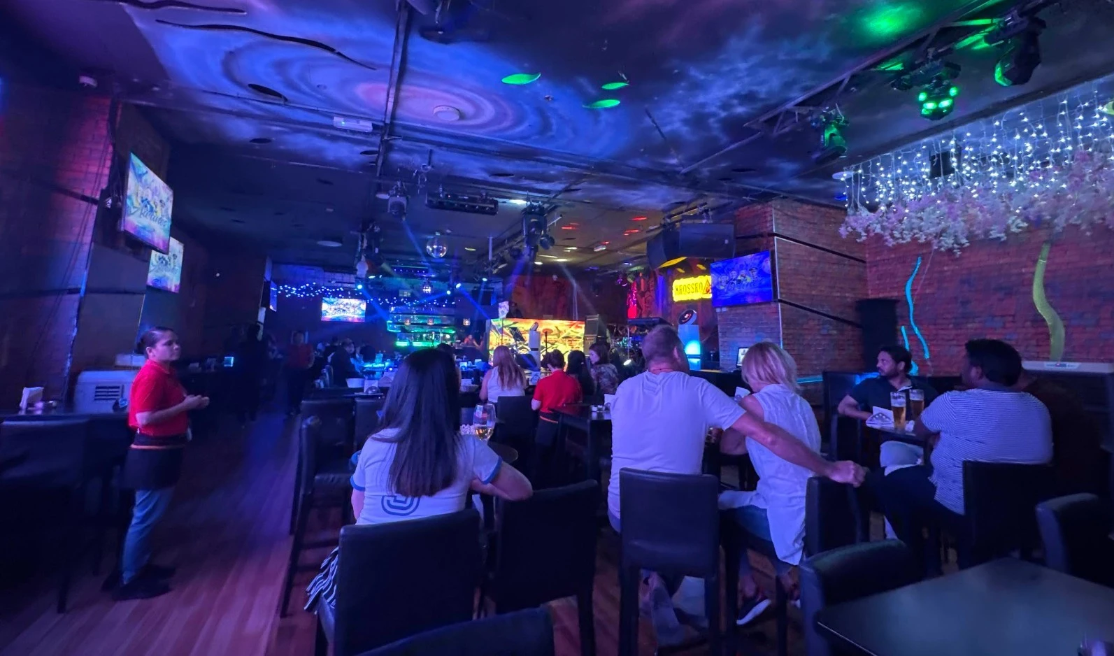 Krossroads Club Doha interior with patrons and colorful lighting.