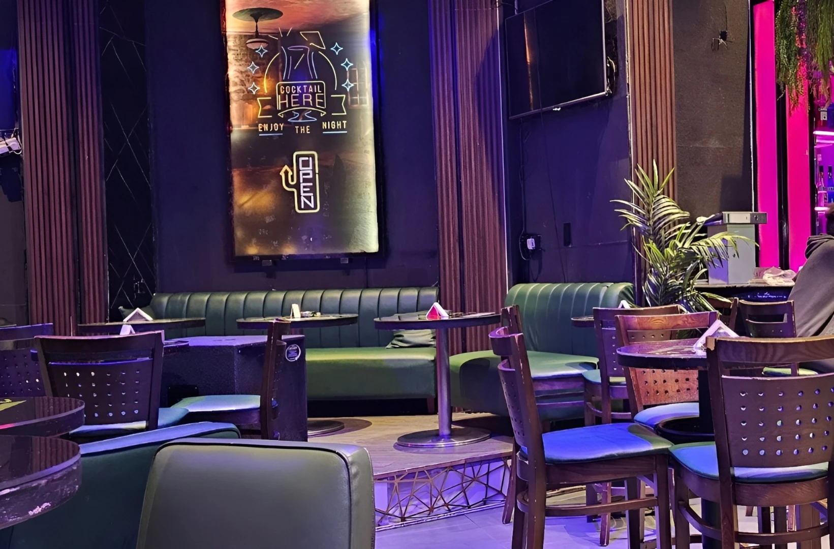 Matrix Club Qatar lounge area with tables and neon sign, Doha.
