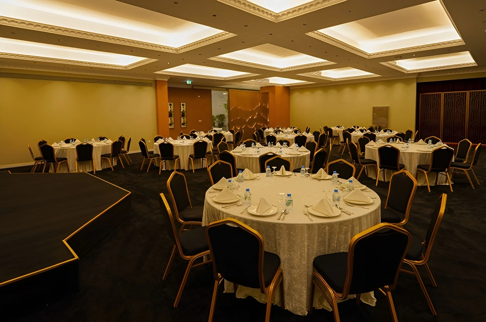 Round tables with white linens at U Venue Doha banquet.