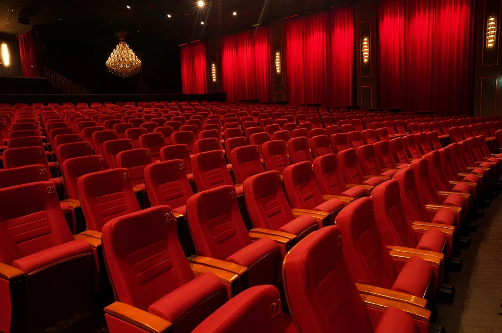 U Venue Doha theater with red seats and chandelier.