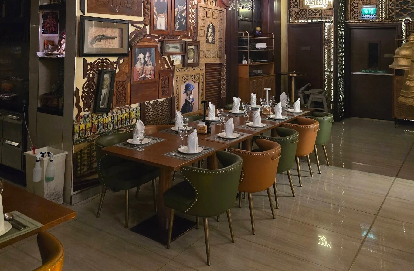 Elegant dining setup at Tanatan Dubai with artistic wall decor.