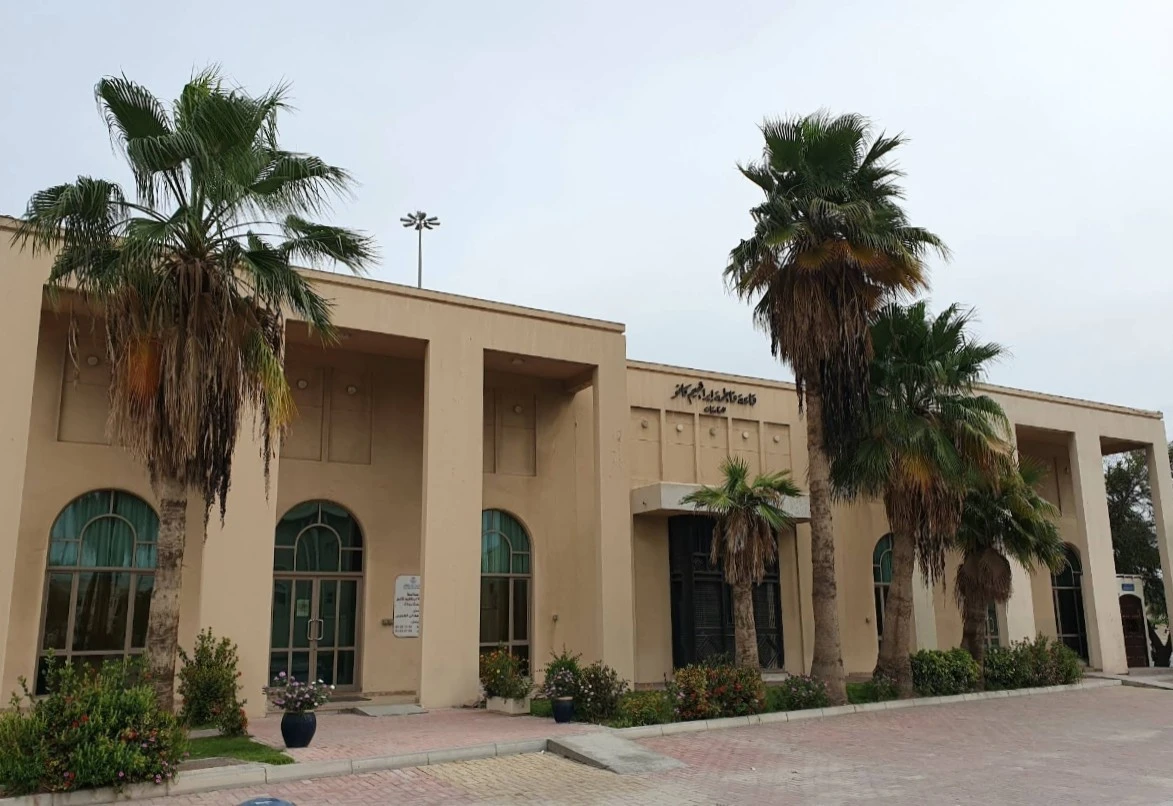 Fatima Kanoo Hall exterior with palm trees, Manama.