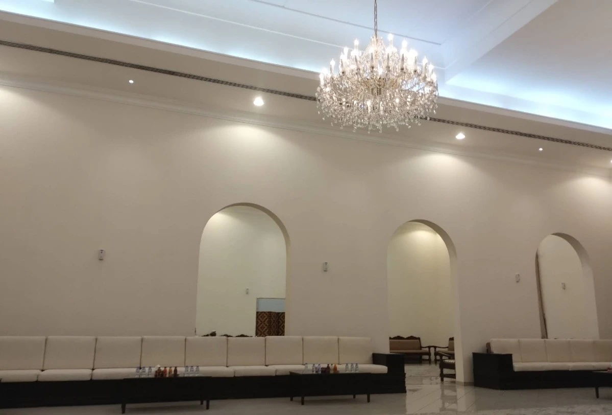 Elegant chandelier in Fatima Kanoo Hall, Manama with arched walls.