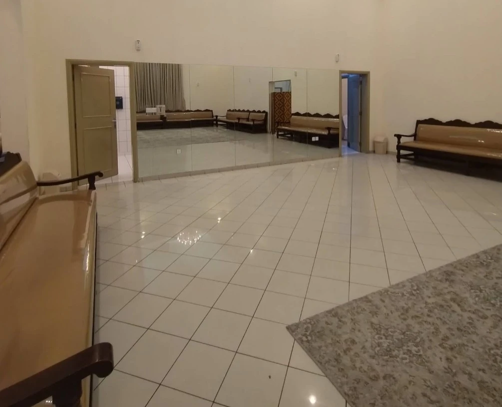 Spacious interior of Fatima Kanoo Hall, Manama with tiled flooring.
