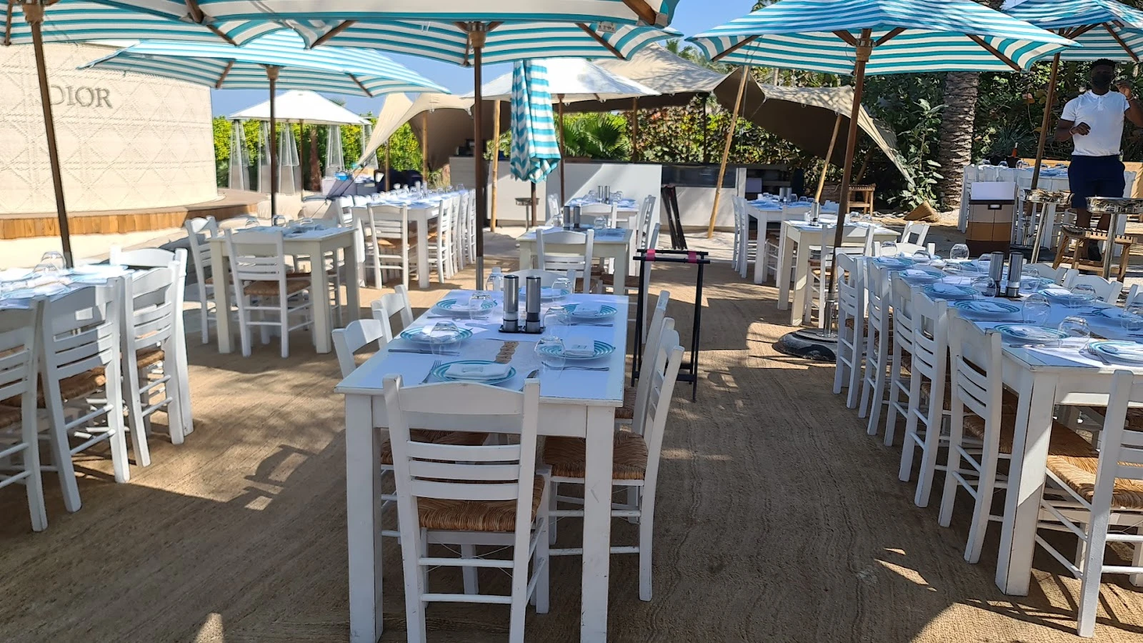 Outdoor dining setup at Nammos Dubai with striped umbrellas.