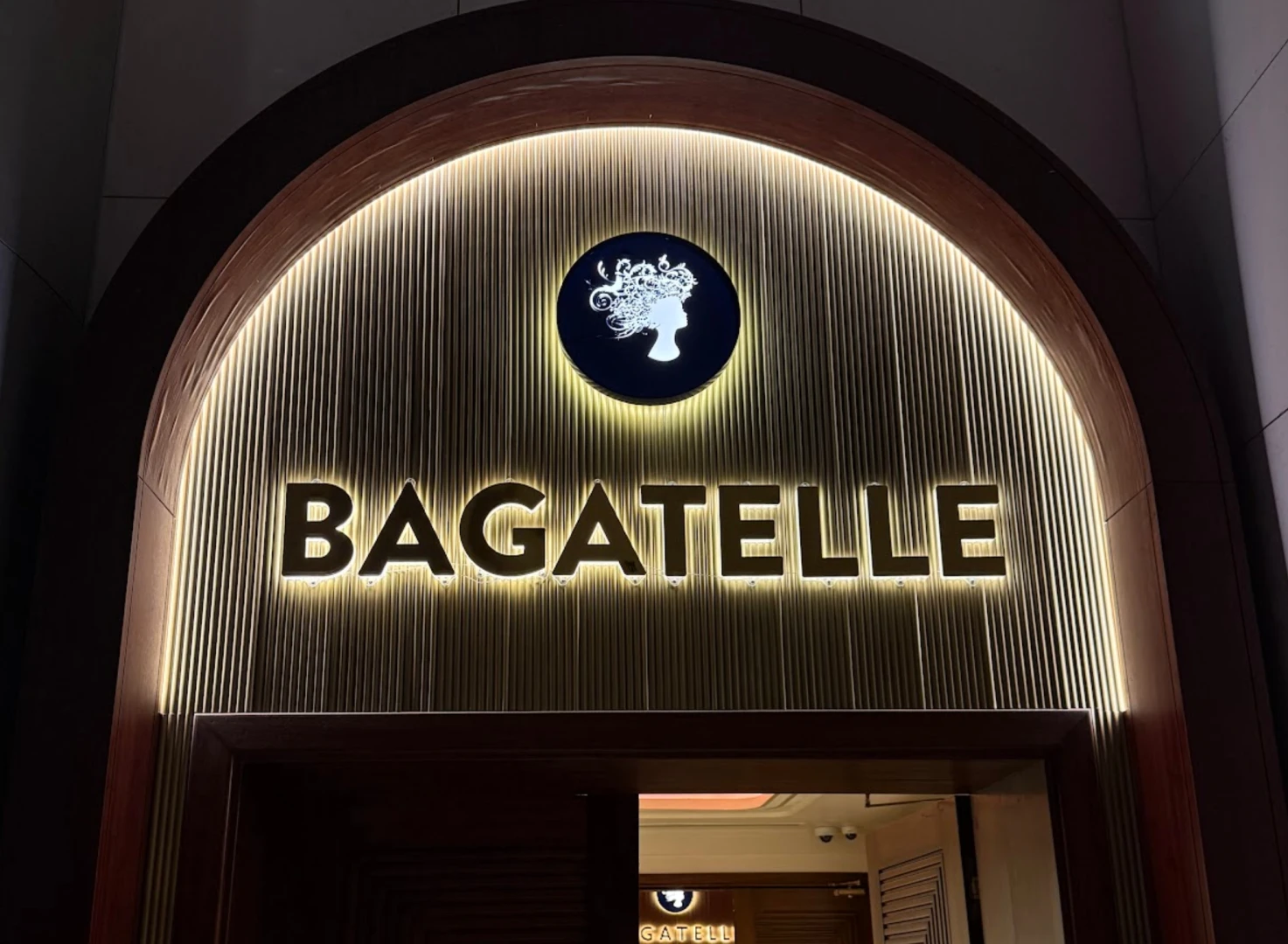 Entrance to Bagatelle Dubai, illuminated sign and logo.