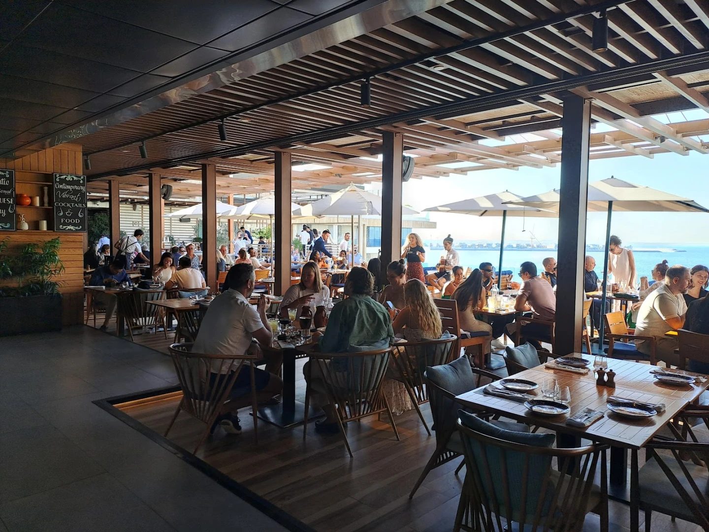 Tasca by Jose Avillez, Dubai, bustling dining area with ocean view.