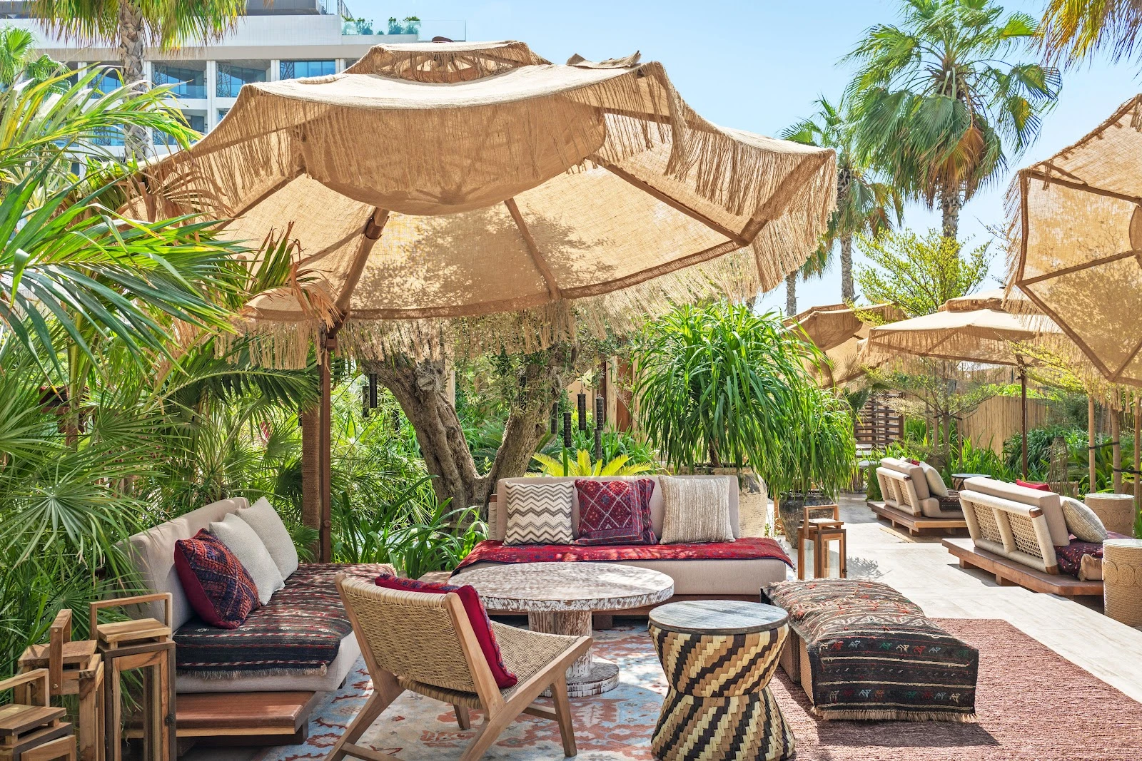 Casa Amor Dubai outdoor seating with lush greenery and umbrellas.