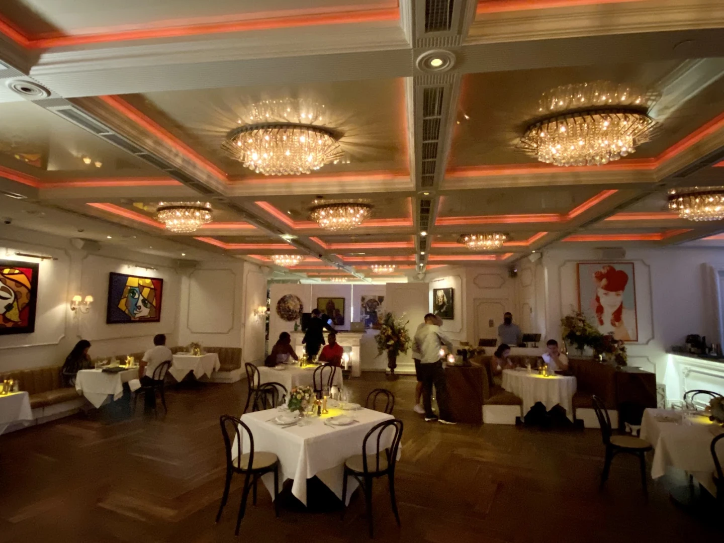 Elegant interior of Bagatelle Dubai with chandeliers and artwork.
