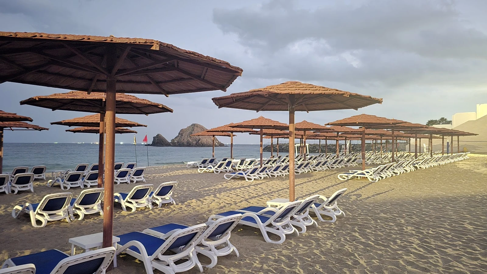 Beachfront loungers and umbrellas at Royal M Hotel, Dubai.