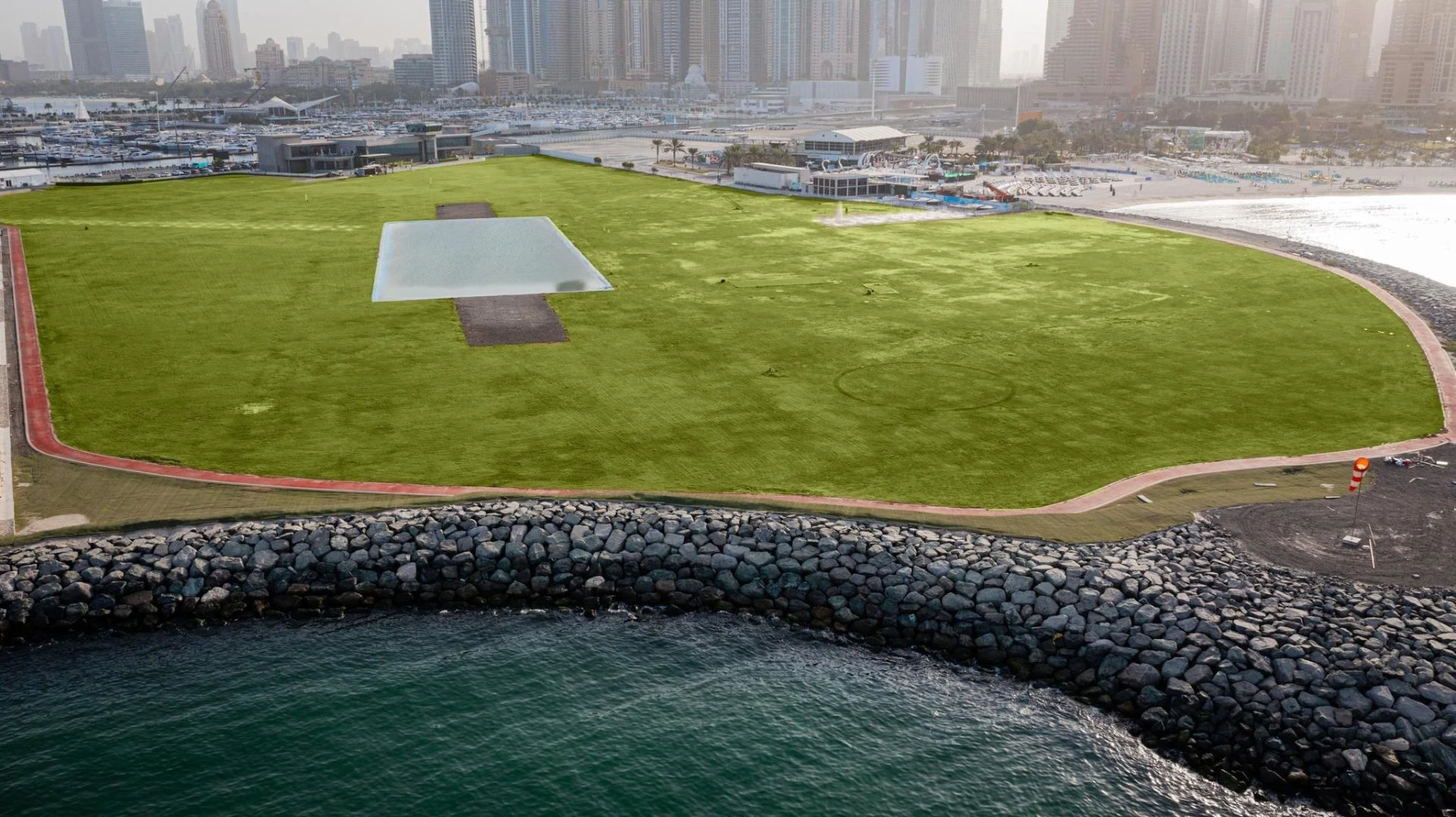 Expansive green lawn and water view at Skydive Dubai, Dubai, UAE.