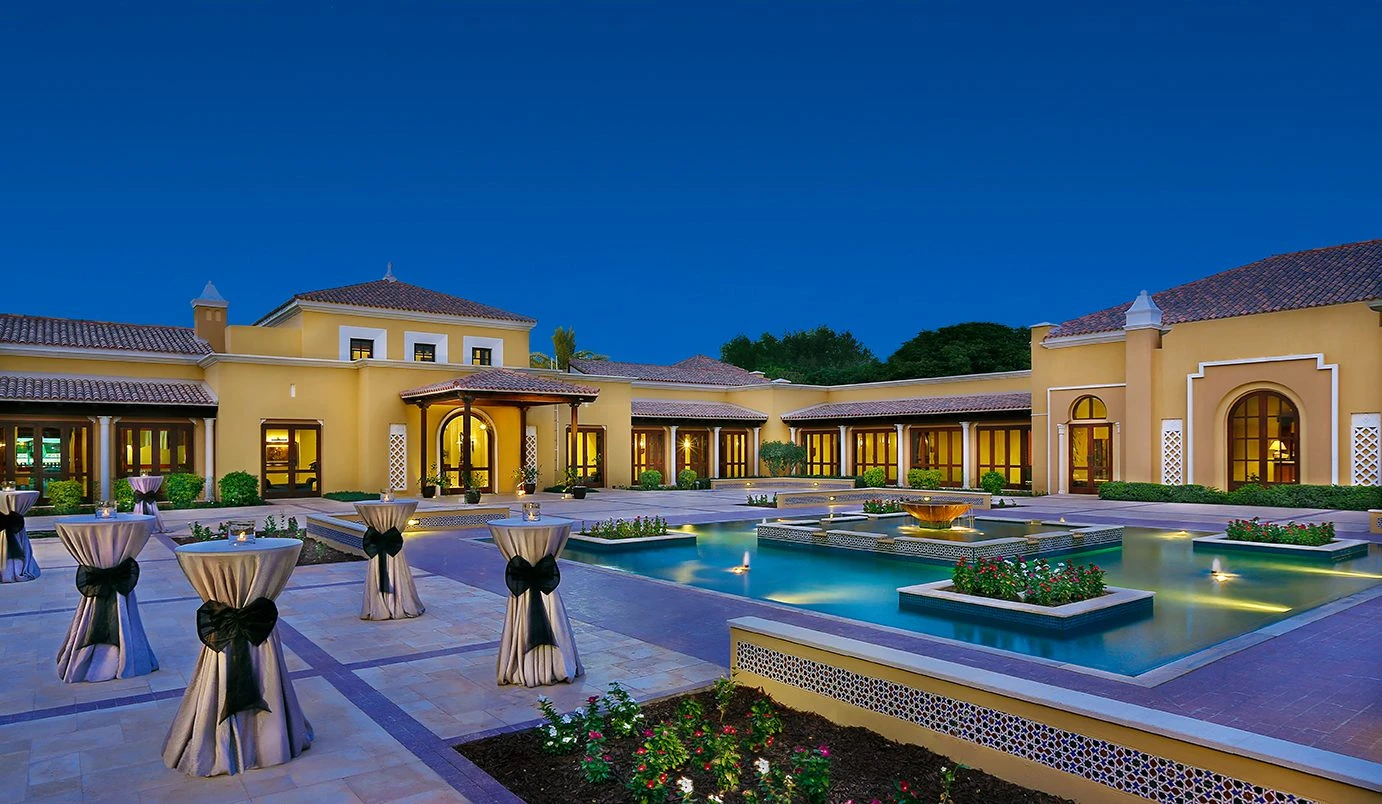 Elegant courtyard with pool and tables at Dubai Polo & Equestrian Club, Dubai.