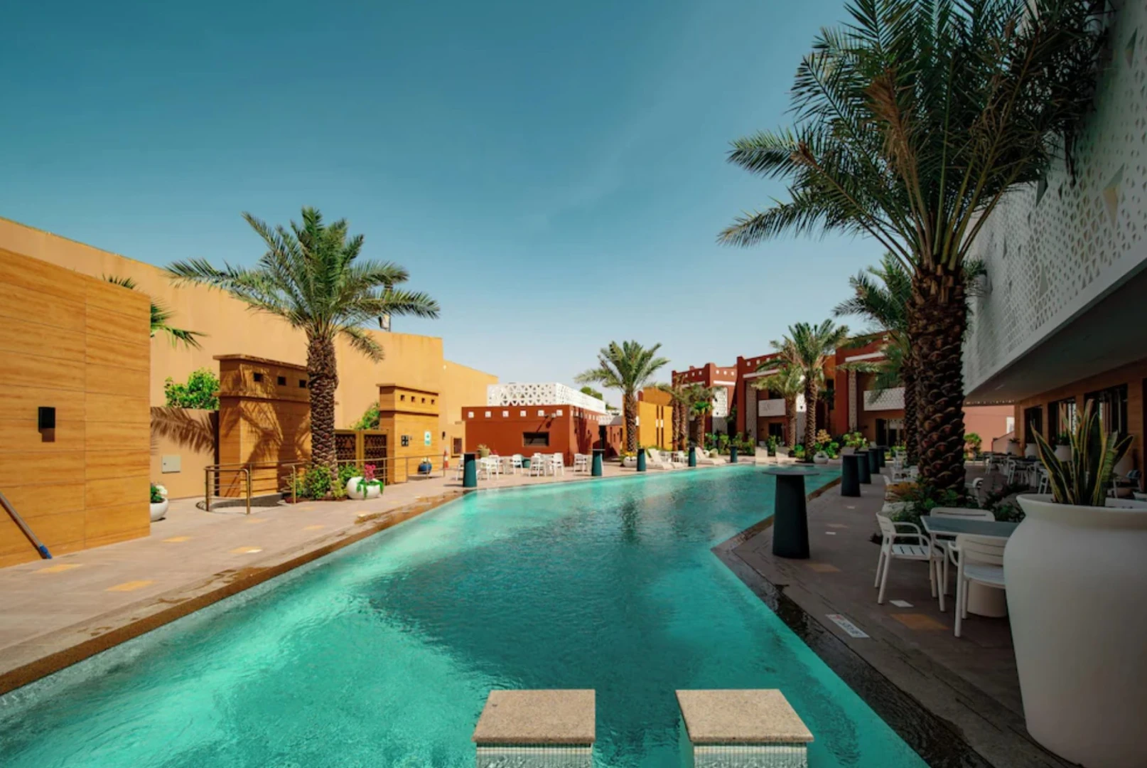 Outdoor pool and palm trees at Vivienda Riyadh Diplomatic Quarter, Riyadh, KSA